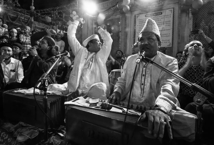 Qawwali being performed by artists at a gathering, while passionately engaging with the audience through their song