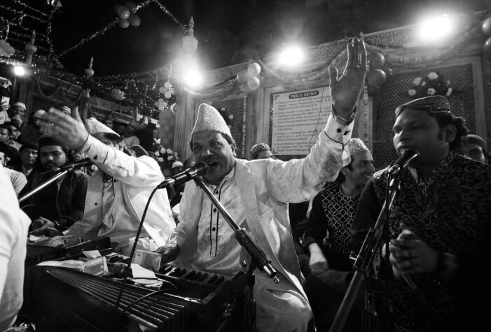 Artists perform Qawwali at a gathering, passionately engaging with the audience through music and rhythmic singing